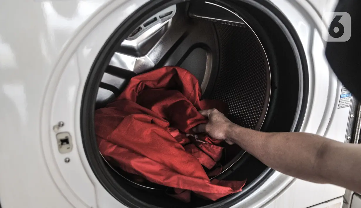 Pelanggan memasukkan pakaian ke dalam mesin cuci di Jaksa Clean Coin Laundry, Jalan Jaksa, Jakarta, Kamis (1/4/2021). Akibat pandemi Covid-19, jasa cuci pakaian mandiri atau self service mengalami sepi pelanggan mencapai 50 persen. (merdeka.com/Iqbal S Nugroho)