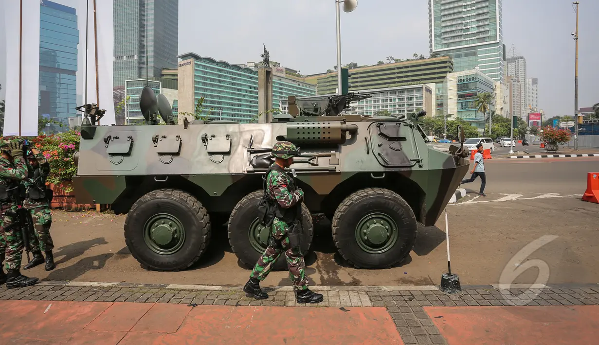 Personil TNI Yonif Mekanik 201 Kodam Jaya bersiaga di samping kendaraan taktis di Kawasan Bundaran Hotel Indonesia, Jakarta Pusat, Selasa (14/4/2105). KAA ke-60 akan berlangsung pada 18-24 April 2015 di Jakarta dan Bandung. (Liputan6.com/Faizal Fanani)