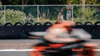 Warga lokal menonton tes pramusim MotoGP di Mandalika dari kebun