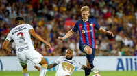 Pemain Barcelona, Frenkie de Jong (kanan) berusaha melepaskan diri dari pengawalan pemain Pumas Unam, Dani Alves (tengah) dalam laga bertajuk Trofeo Joan Gamper, Minggu (7/8/2022) malam waktu setempat. (AP Photo/Joan Monfort)