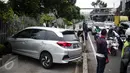 Arus lalu lintas di lokasi mobil yang menabrak separator busway matraman arah kampung melayu, Jakarta, Sabtu (25/2). Akibat kecelakaan ini lalu lintas kawasan jalan matraman mengarah kampung melayu tersendat. (Liputan6.com/Faizal Fanani)