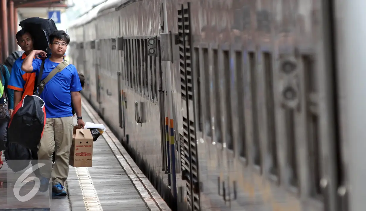 Pemudik membawa barang bawaannya berjalan menuju pintu kedatangan saat tiba di Stasiun Senen, Jakarta, Sabtu (9/7). Puncak arus balik pemudik di stasiun Senen diperkirakan terjadi pada besok Minggu (10/7). (Liputan6.com/Johan Tallo)