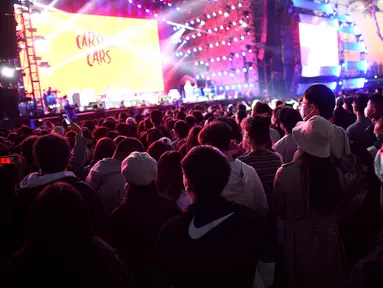 Orang-orang yang memakai masker menyaksikan penampilan sebuah band pada Festival Musik Rye yang digelar selama dua hari di Beijing pada 18 Oktober 2020. (Photo by Noel Celis / AFP)