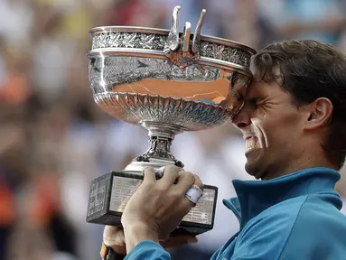 Rafael Nadal mengangkat trofi Prancis Terbuka 2018 setelah mengalahkan petenis Austria, Dominic Thiem pada final di Roland Garros stadium, Paris, (10/6/2018). Nadal menang tiga set 6-4, 6-3, 6-2. (AP/Alessandra Tarantino)