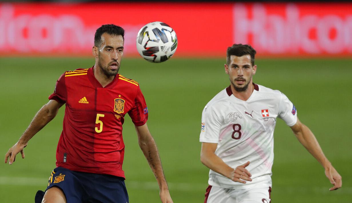 Gelandang Spanyol, Sergio Busquets (kiri) mengontrol bola dari kawalan pemain Swiss, Remo Freuler  pada pertandingan  UEFA Nations League di Alfredo Di Stefano, Madrid, Spanyol (10/10/2020). Madrid menang tipis atas Swiss 1-0. (AP Photo/Manu Fernandez)