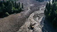 Foto udara yang diambil dengan drone ini menunjukkan petugas penyelamat bekerja di lokasi tanah longsor di wilayah Racha, Georgia barat, Jumat (4/8/2023). Sedikitnya enam orang tewas akibat tanah longsor di wilayah Racha. (STRINGER/AFP)
