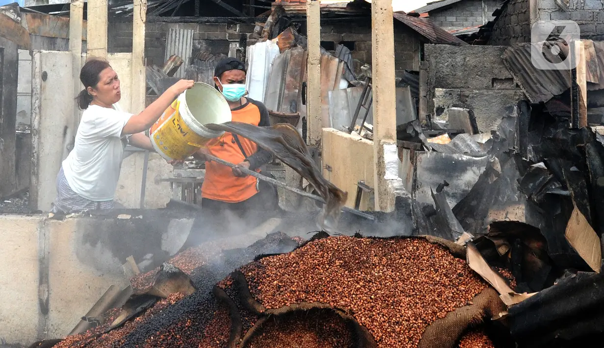 Pedagang menyiram air pada sisa bara api lokasi kebakaran Pasar Ciputat, Tangerang Selatan, Banten, Kamis (12/5/20222). Kebakaran Pasar Ciputat pada kemarin sore menghanguslan lebih dari 50 kios dan rumah warga yang berada di sekitar pasar. (merdeka.com/Arie Basuki)