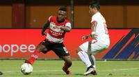 Pemain Madura United, David Laly, berduel dengan bek Persija Jakarta, Tony Sucipto, dalam laga pekan ke-14 Shopee Liga 1 2019 yang berakhir imbang 2-2 di Stadion Gelora Madura, Pamekasan, Jumat (16/8/2019). (Bola.com/Aditya Wany)