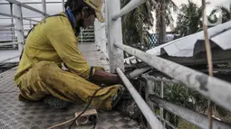 Petugas Sudin Bina Marga Jakarta Timur memperbaiki jembatan penyeberangan orang (JPO) di Jalan Otto Iskandardinata (Otista), Jatinegara, Rabu (9/2/2022). Perbaikan JPO itu tindak lanjut pasca insiden tertimpa pohon tumbang pada November tahun lalu akibat cuaca ekstrem. (merdeka.com/Iqbal S Nugroho)