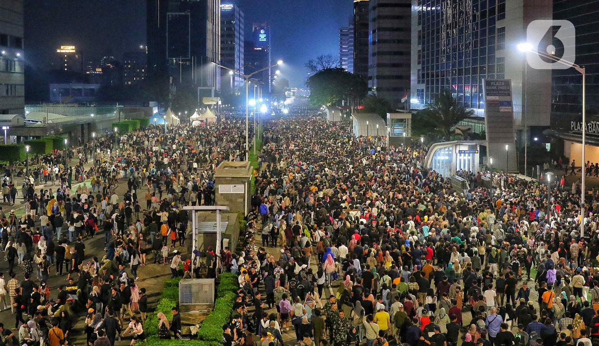 Ribuan pengunjung padati kawasan Bundaran HI, Jakarta, untuk merayakan pergantian tahun 2023, Sabtu (31/12/2022). Kemeriahan begitu terasa dalam momen perayaan tahun baru 2023 di car free night yang digelar di sepanjang Jalan Sudirman-Jalan MH Thamrin. (Liputan6.com/Angga Yuniar)