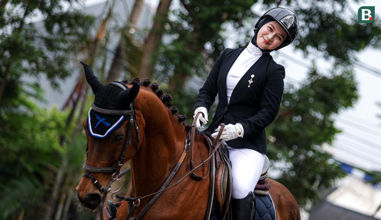 Selebritas Indonesia, Melody Laksani berpose di atas kuda saat bersiap berkompetisi dalam cabang olahraga berkuda nomor show jumping Turnamen Olahraga Selebriti Indonesia (TOSI) Season 3 yang berlangsung di Arthayasa Stable, Depok, Jawa Barat, Jumat (01/11/2024). (Bola.com/Bagaskara Lazuardi)
