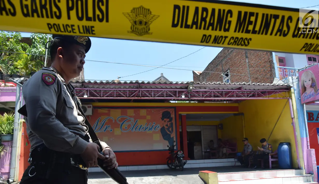 Polisi bersenjata mengawal reka adegan pembunuhan penghuni rehabilitasi sosial Argorejo Sunan Kuning Semarang, Jawa Tengah, Selasa (18/9). Pelaku memeragakan 29 adegan pembunuhan yang dilakukan di kamar korban. (Liputan6.com/Gholib)