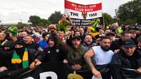 Para pengunjuk rasa berkumpul di luar stadion Old Trafford untuk berdemonstrasi menentang pemilik Manchester United menjelang pertandingan Liga Inggris melawan Liverpool di Old Trafford, pada Senin, 22 Agustus 2022. Protes besar-besaran oleh penggemar MU sebelum kick-off ditujukan kepada pemilik klub, keluarga Glazer. (Foto oleh ANTHONY DEVLIN / AFP)