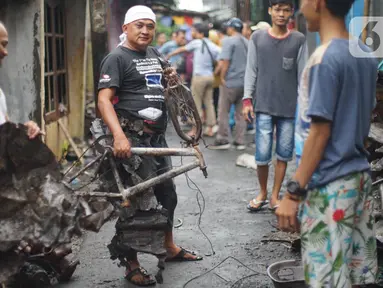 Warga membersihkan puing sisa kebakaran di kawasan padat penduduk di Jalan Kebon Jeruk 4, RT 004 RW 06, Kelurahan Maphar, Kecamatan Taman Sari, Jakarta, Jumat (7/2/2020). Sebanyak 29 unit mobil dikerahkan untuk melakukan pemadaman yang terjadi pada Kamis (6/2) malam. (Liputan6.com/Immanuel Antonius)