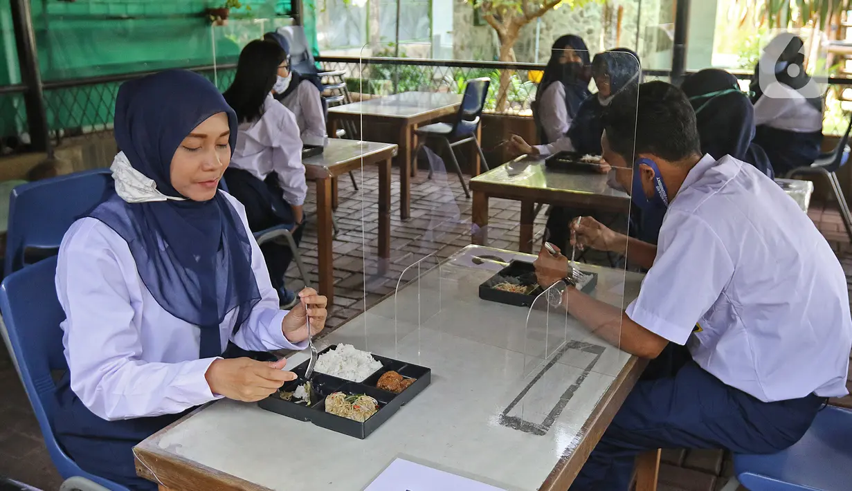 Siswa dibatasi saat makan di Sekolah Nasional Satu (Nassa School), Bekasi, Rabu (24/6/2020). Menuju kenormalan baru, Nassa School memberlakukan protokol kesehatan COVID-19 dengan membatasi jumlah siswa serta penggunaan teknologi ultraviolet untuk membersihkan kelas. (Liputan6.com/Herman Zakharia)