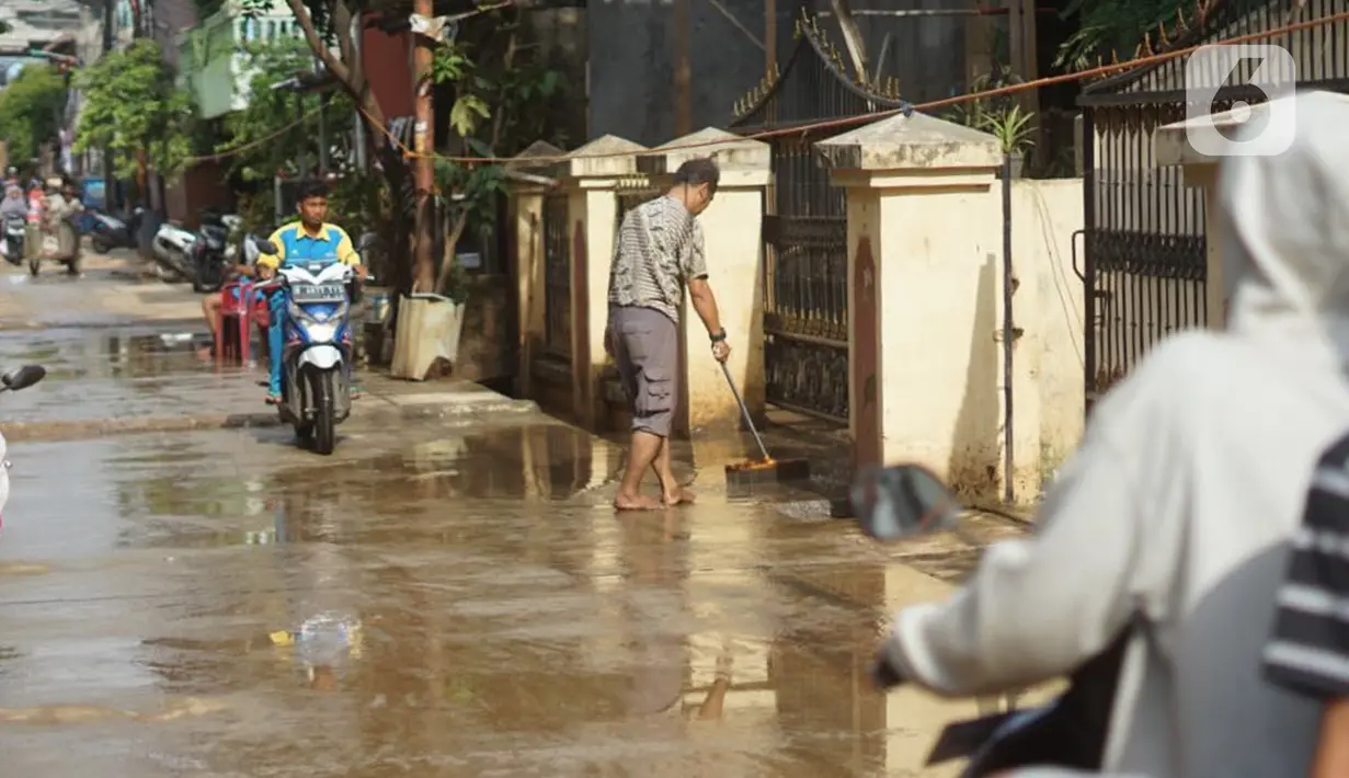 Warga membersihkan lumpur sisa banjir yang sebelumnya merendam kawasan Cipinang Muara, Jakarta, Rabu (26/2/2020). Banjir dari luapan Sungai Kalimalang tersebut menyebabkan warga harus bekerja ekstra untuk membersihkan perabotan serta lumpur dan sampah. (Liputan6.com/Immanuel Antonius)
