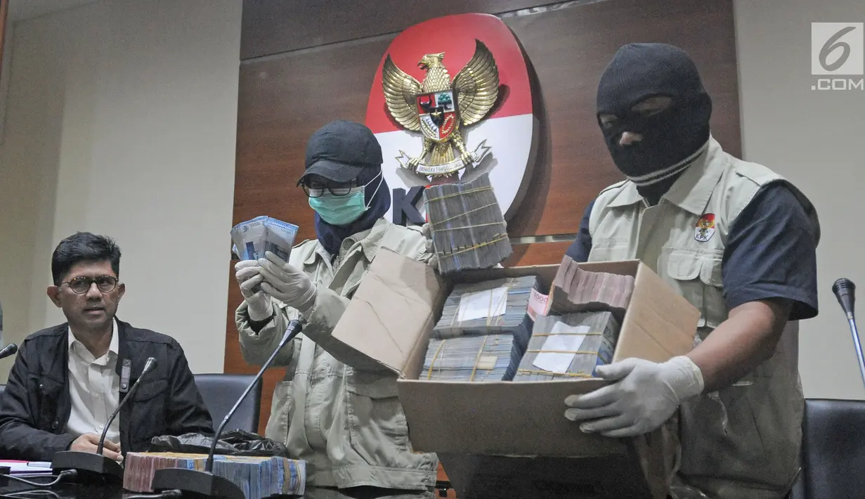 Penyidik KPK menunjukkan barang bukti uang 1 miliar rupiah hasil OTT Bupati Lampung Tengah Mustafa di Gedung KPK, Jakarta, Kamis (15/02). Uang suap tersebut akan digunakan untuk pembangunan proyek infrastruktur. (Liputan6.com/Herman Zakharia)