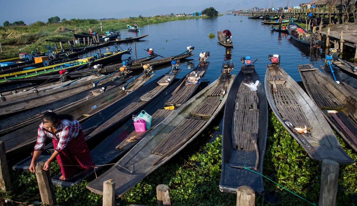 Seorang wanita mengikat perahunya di sepanjang dermaga kampung terapung Danau Inle, Negara Bagian Shan, Myanmar, Senin (18/2). Masyarakat di tempat ini tinggal di rumah panggung dari kayu yang dibangun di atas permukaan air. (Ye Aung THU/AFP)
