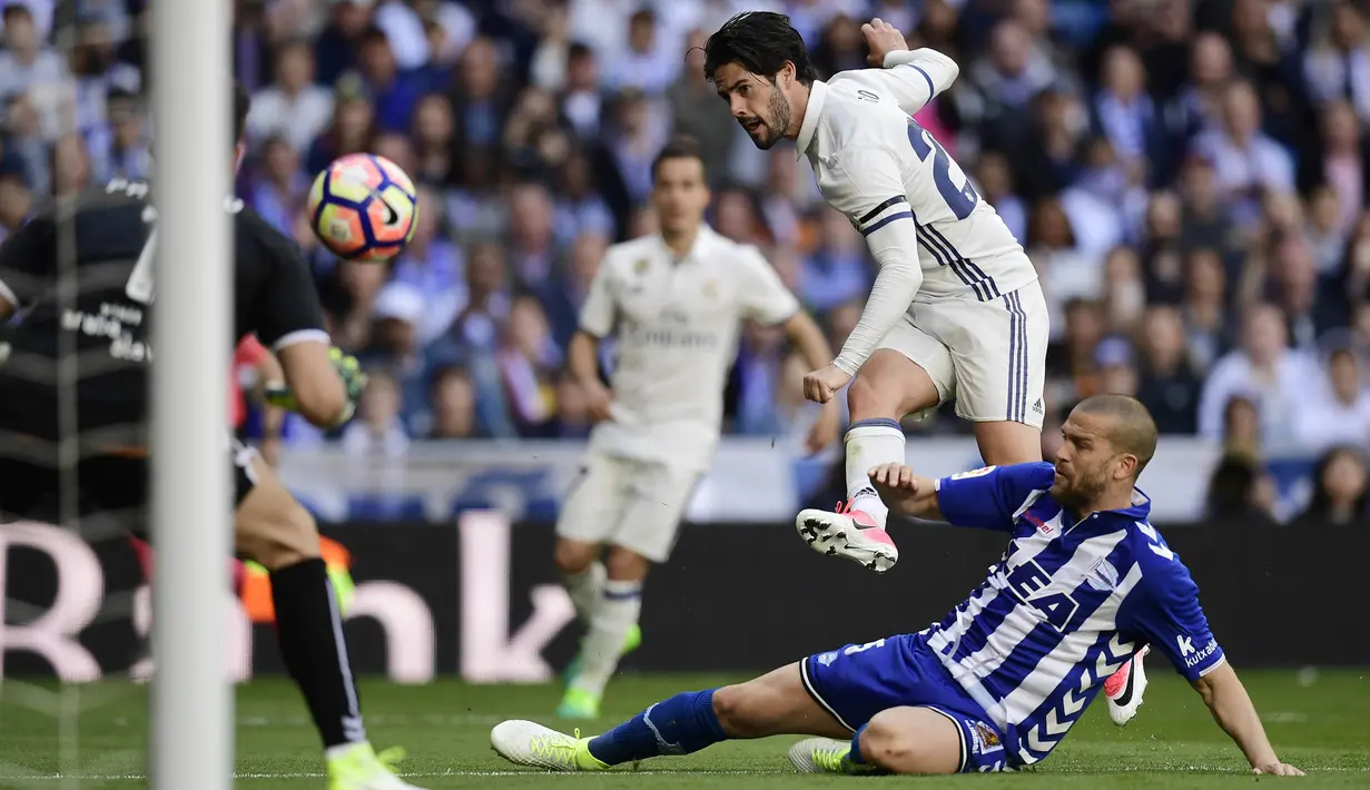 Gelandang Real Madrid, Isco, melesatkan tendangan ke arah gawang kiper Alaves, Fernando Pacheco. Isco tampil memukau dengan mencetak satu dari tiga gol Real Madrid. (AFP/Javier Soriano)