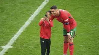Seorang bocah yang nekad masuk lapangan atau kerap disebut pitch invader berhasil melakukan selfie dengan Cristiano Ronaldo sebelum duel Turki melawan Portugal di laga grup F Euro 2024 (AP)