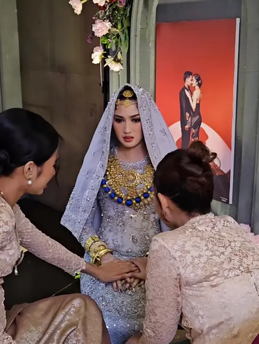 Aksesori tradisional bernuansa emas dan biru dari @sistawedding turut mempermanis tampilannya, menambahkan kesan anggun dan berwibawa dalam momen sakral tersebut. Detail dan perpaduan warna yang harmonis menjadikan penampilannya tampak cantik manglingi di hari bahagianya. [@renzilazuardi/@marlenehariman].