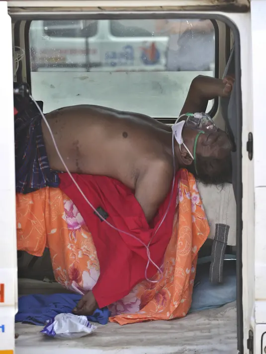 Pasien COVID-19 terbaring di dalam kendaraan untuk dirawat di rumah sakit pemerintah khusus COVID-19 di Ahmedabad, 22 April 2021. Otoritas India bergegas membawa tangki oksigen ke rumah sakit tempat pasien COVID-19 tercekik di tengah gelombang virus corona terburuk di dunia. (AP Photo/ Ajit Solanki)