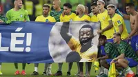 Para pemain Brasil menunjukkan spanduk untuk mendukung legenda sepak bola Brasil Pele pada akhir pertandingan&nbsp; babak 16 besar Piala Dunia 2022 melawan Korea Selatan di Stadion 974, Doha, Qatar, Selasa, 6 Desember 2022. Laga itu dimenangkan Brasil dengan skor 4-1. (AP Photo/Andre Penner)