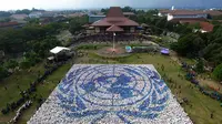 Mahasiswa baru Universitas Gadjah Mada, Yogyakarta, mempromosikan perdamaian dunia dengan membentuk formasi lambang PBB. (Liputan6.com/Yanuar H)