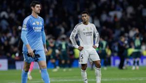 Gelandang Real Madrid asal Inggris #05, Jude Bellingham (kanan), dan kiper Real Madrid asal Belgia #01, Thibaut Courtois, bereaksi setelah pertandingan pekan ke-6 League Phase UEFA Champions League antara Real Madrid CF dan Manchester City di Stadion Santiago Bernabeu di Madrid pada 10 Desember 2025. (Oscar DEL POZO/AFP)