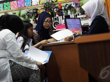 Sejumlah murid didampingi orang tuanya menerima rapor di SDN Menteng 01, Jakarta, Senin (5/1/2015). (Liputan6.com/Faizal Fanani)