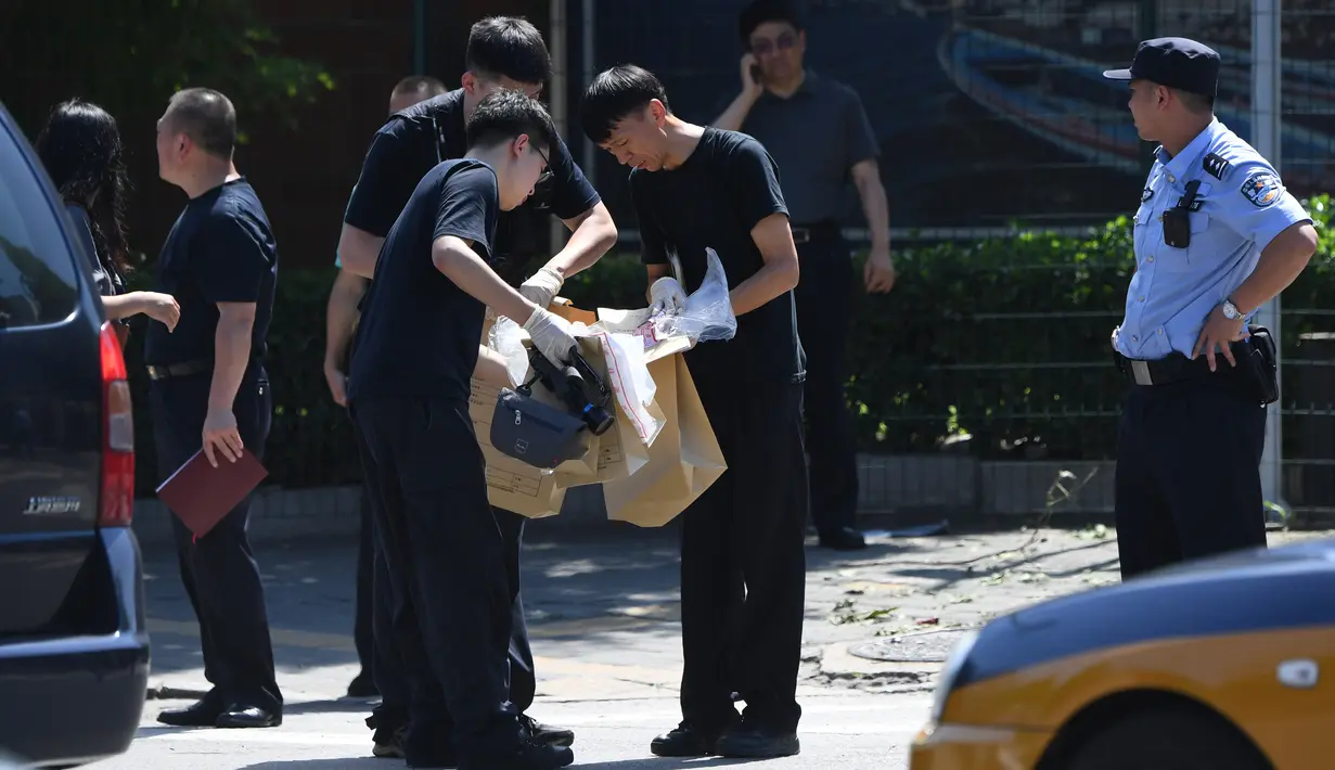 Petugas keamanan berada di lokasi ledakan bom yang terjadi luar kedutaan besar Amerika Serikat di Beijing, Kamis (26/7). Menurut juru bicara Kedutaan AS, satu-satunya korban adalah tersangka pelaku yang meledakkan alat peledak. (AFP/Greg BAKER)
