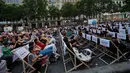Orang-orang menonton film gratis yang diputar di ruang terbuka di jalan Champs Elysees, Paris (7/7/2019). Pemutaran bioskop luar ruangan gratis di Paris musim panas ini sudah kedua kalinya dibuat. (AP Photo/Michel Euler)