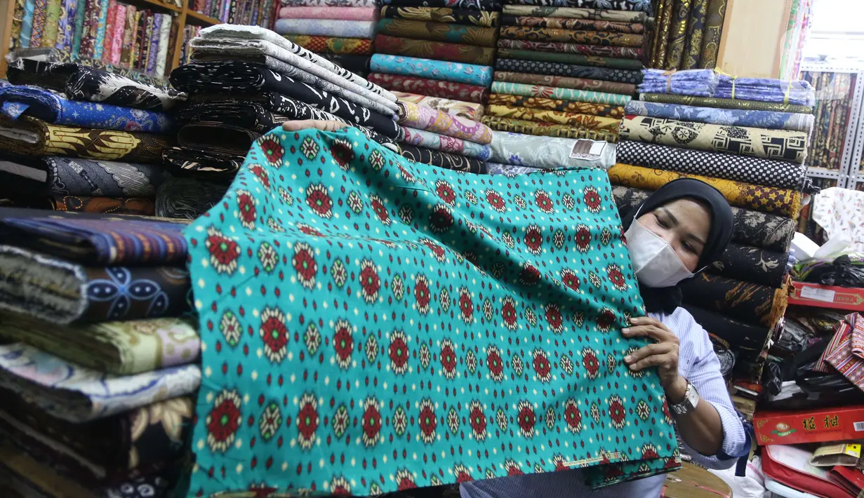 Pekerja menyusun bahan kain di Pasar Tanah Abang, Jakarta, Sabtu (27/11/2021). Utilisasi industri tekstil dan produk tekstil dalam negeri menunjukkan kinerja yang positif menjelang akhir 2021. Utilisasi industri itu berada di posisi 80 - 85 persen pada awal kuartal IV/2021. (Liputan6.com/Angga Yunia