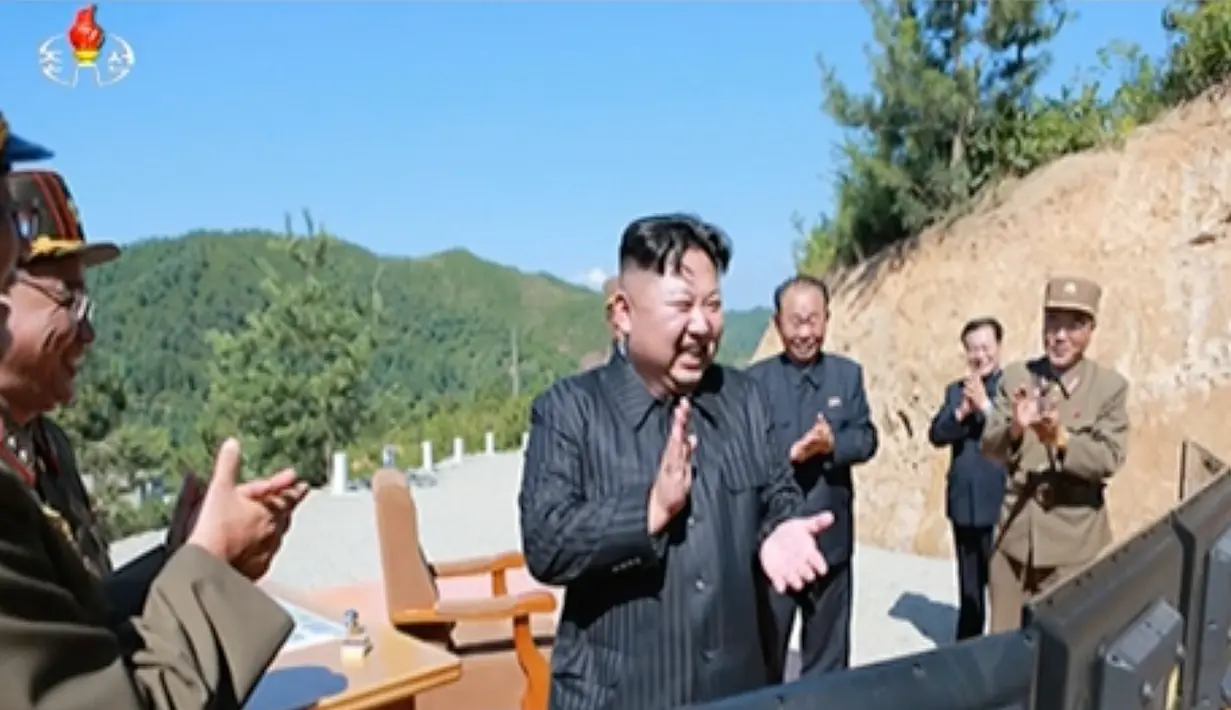 Pemimpin Korut, Kim Jong-un bertepuk tangan usai peluncuran rudal balistik antarbenua Hwasong-14, ICBM, di barat laut Korea Utara. Uji rudal balistik antarbenua ini diumumkan pada hari Selasa, 4 Juni 2017. (KRT via AP Video)
