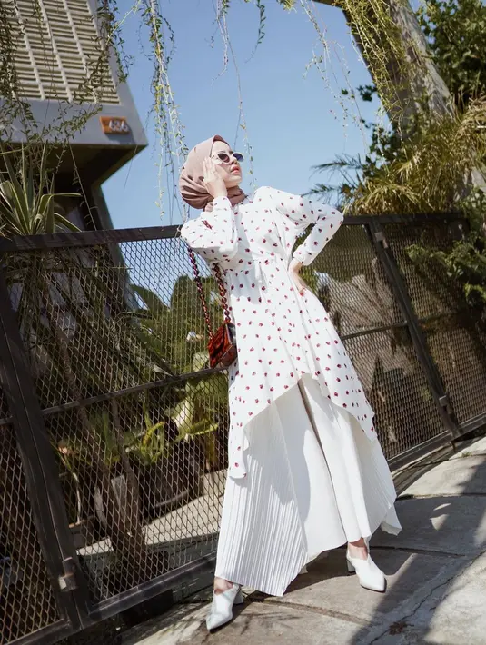 Gaya Aghnia Punjabi mengenakan atasan berwarna putih motif yang dipadukan dengan kulot senada dapat jadi inspirasi OOTD. Dalam penampilannya, wanita yang akrab disapa Nia ini tampak makin memesona dengan memakai kacamata. (Liputan6.com/IG/@aghniapunjabi)