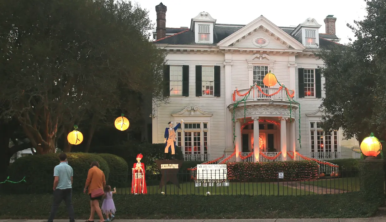 Para pejalan kaki melihat dekorasi Halloween di depan sebuah rumah di New Orleans, Louisiana, Amerika Serikat, pada 10 Oktober 2020. Tiga pekan sebelum perayaan Halloween, warga New Orleans mulai mendekorasi rumah mereka untuk menyambut festival tersebut. (Xinhua/Lan Wei)