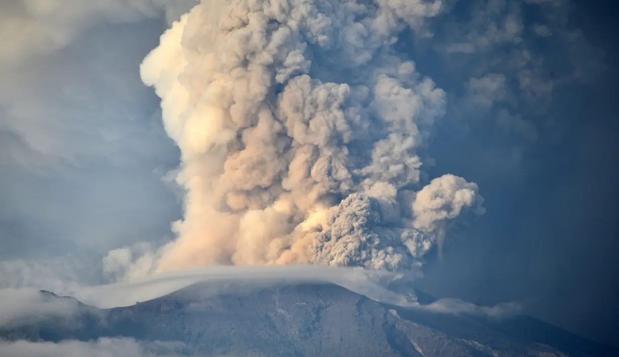 Asap tebal keluar dari Gunung Agung di Kabupaten Karangasem, Bali (28/11). Kepulan asap tebal ini terjadi karena ada dua lubang asap vulkanis di Gunung Agung. (AFP Photo/Sonny Tumbelaka)