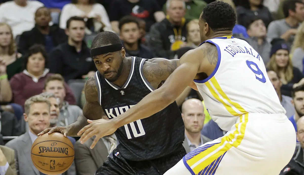 Pemain Sacramento Kings, Ty Lawson (kiri) berusaha melewati hadangan pemain Golden State Warriors, Andre Iguodala pada laga NBA di Golden 1 Center, Sacramento, (8/1/2017). Warriors menang 117-106. (AP/Rich Pedroncelli)