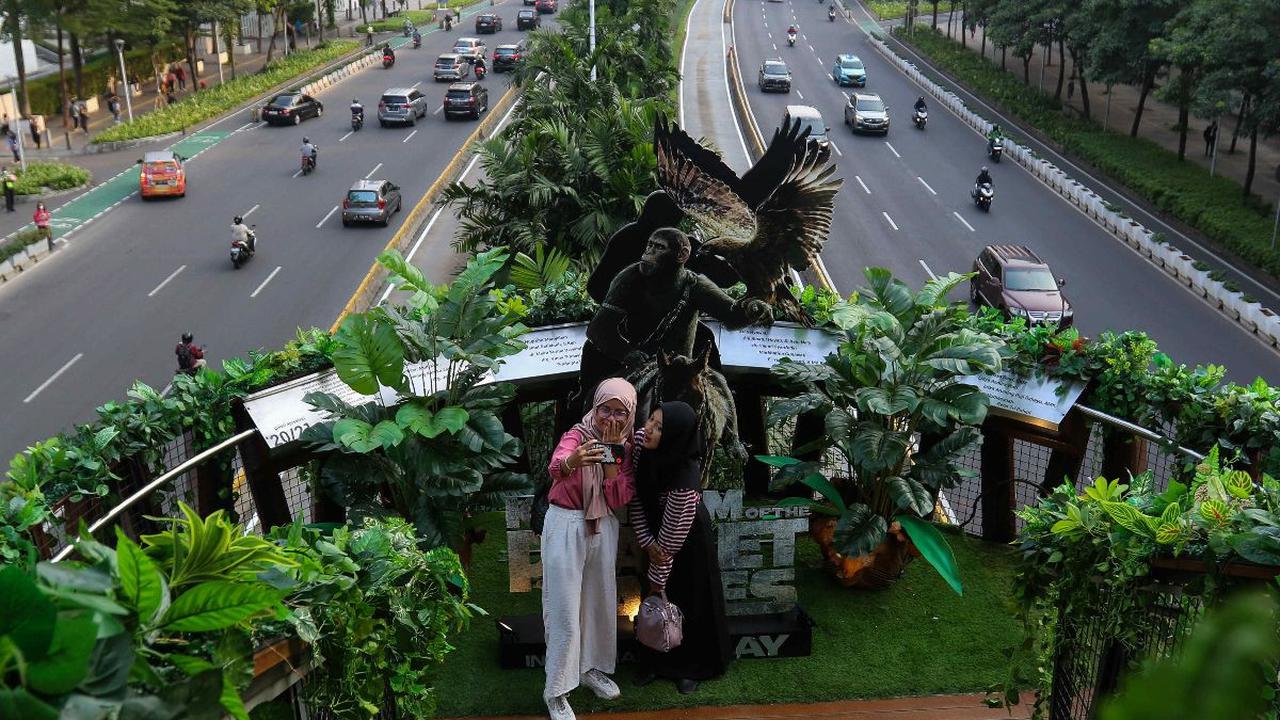 Warga berswafoto di Jembatan Penyeberangan Orang (JPO) Phinisi di Jalan Jenderal Sudirman, Jakarta, Jumat (10/5/2024). JPO Phinisi tiba-tiba menjelma bak hutan belantara. Jembatan estetik itu dipenuhi dedaunan dan akar-akar tumbuhan yang menjuntai. Liputa