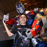 Augie Fantinus ceria berpose bersama Optimus Prime, salah satu tokoh Transformers (Galih W Satria/Bintang.com)