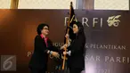 Ketua Dewan Pendiri, Debby Chintya Dewi memberikan bendera PARFI 56 kepada Ketua Umum Parfi 56, Marcella Zalianti pada acara pengukuhan dan pelantikan pengurus besar PARFI 56, Jakarta, Senin (24/10). (Liputan6.com/Herman Zakharia)