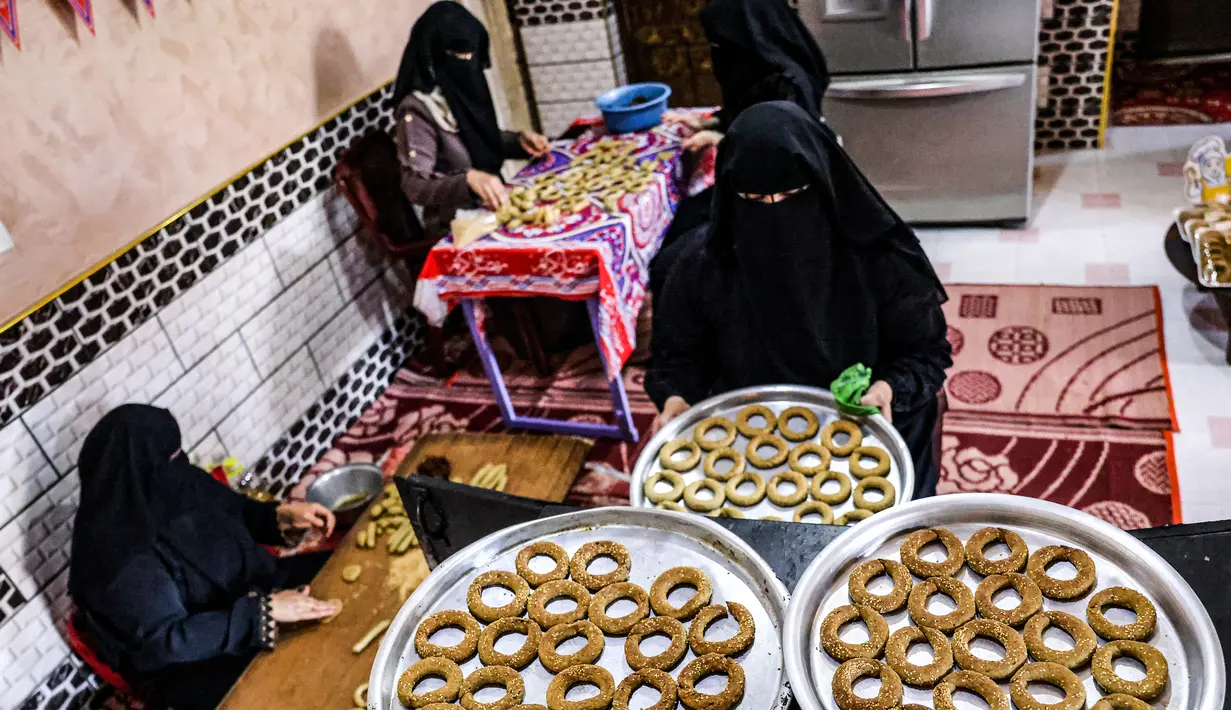 Kesibukan anggota keluarga Palestina menyiapkan kue-kue tradisional untuk dijual sebagai persiapan liburan Idul Fitri mendatang, di kota Rafah, Jalur Gaza, Selasa (4/5/2021). Pembuatan kue tradisional untuk Hari Raya Idul Fitri atau Lebaran yang menandai akhir bulan Ramadhan. (KATA KHATIB/AFP)