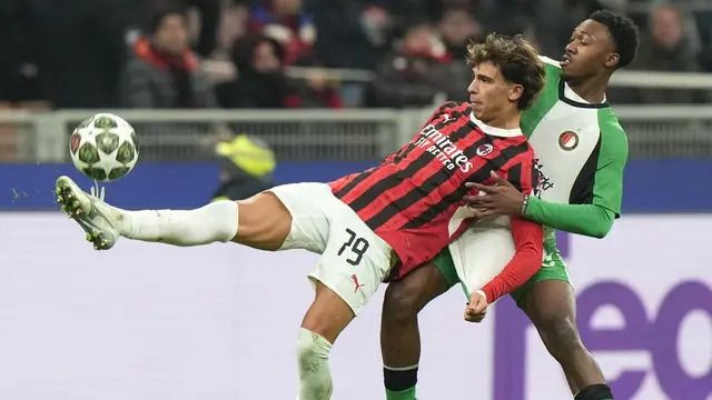 Pemain AC Milan, Joao Felix berebut bola dengan pemain Feyenoord, Antoni Milambo di leg II playoff 16 besar Liga Champions 2024-2025. (c) AP Photo/Luca Bruno