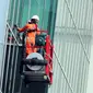 Pekerja gondola membersihkan kaca bagian luar salah satu gedung bertingkat di kawasan Kuningan, Jakarta, Selasa (3/6). Menaker Hanif Dhakiri mengatakan angka kecelakaan kerja secara nasional masih sangat tinggi. (Liputan6.com/Helmi Afandi)