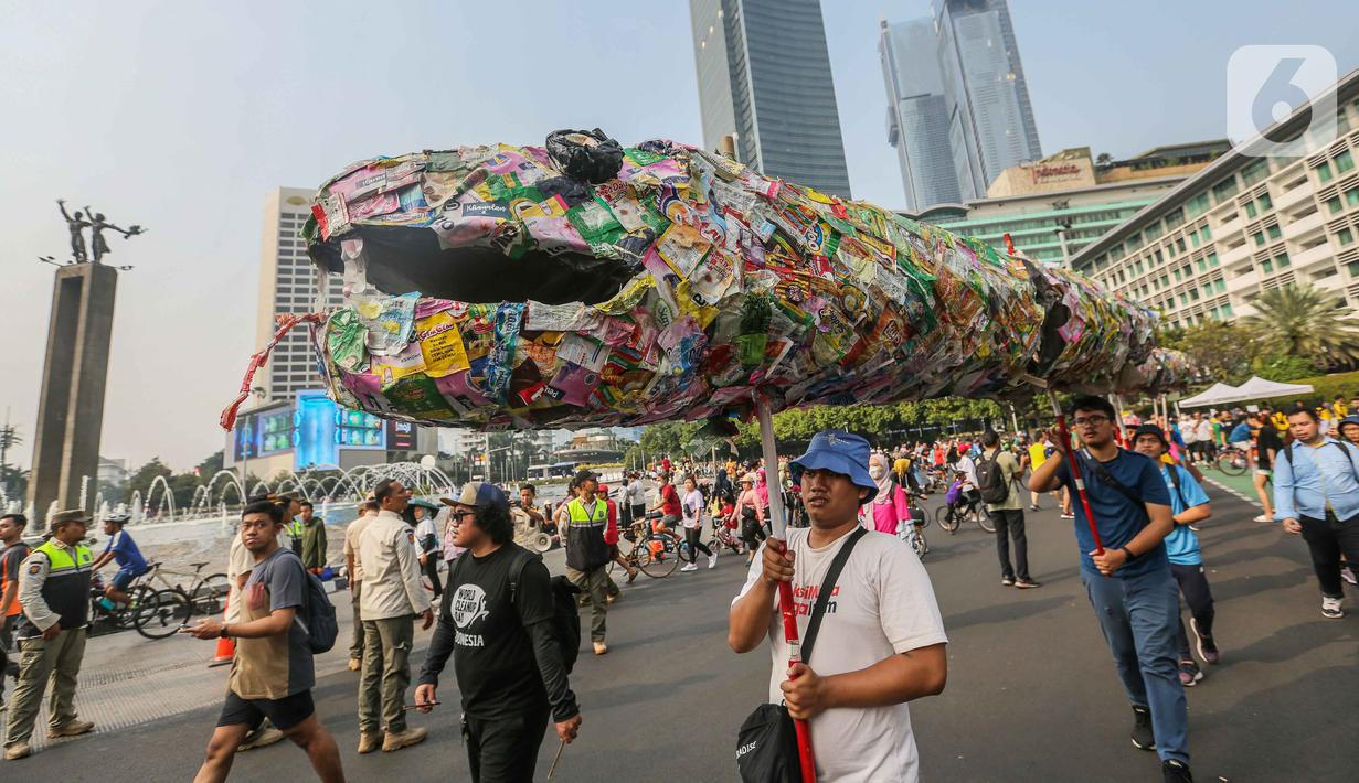 Instalasi ular dari sampah plastik saset saat pawai bebas plastik di Kawasan Sudirman, Jakarta, Minggu (30/7/2023). (Liputan6.com/Faizal Fanani)