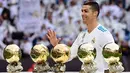 Bintang Real Madrid, Cristiano Ronaldo berpose dengan kelima trofi Ballon d'Or sebelum laga Real Madrid vs Sevilla di Stadion Santiago Bernabeu, Sabtu (9/12). Ronaldo hanya berpose dengan kelima trofi Ballon d'Or seorang diri. (PIERRE-PHILIPPE MARCOU/AFP)