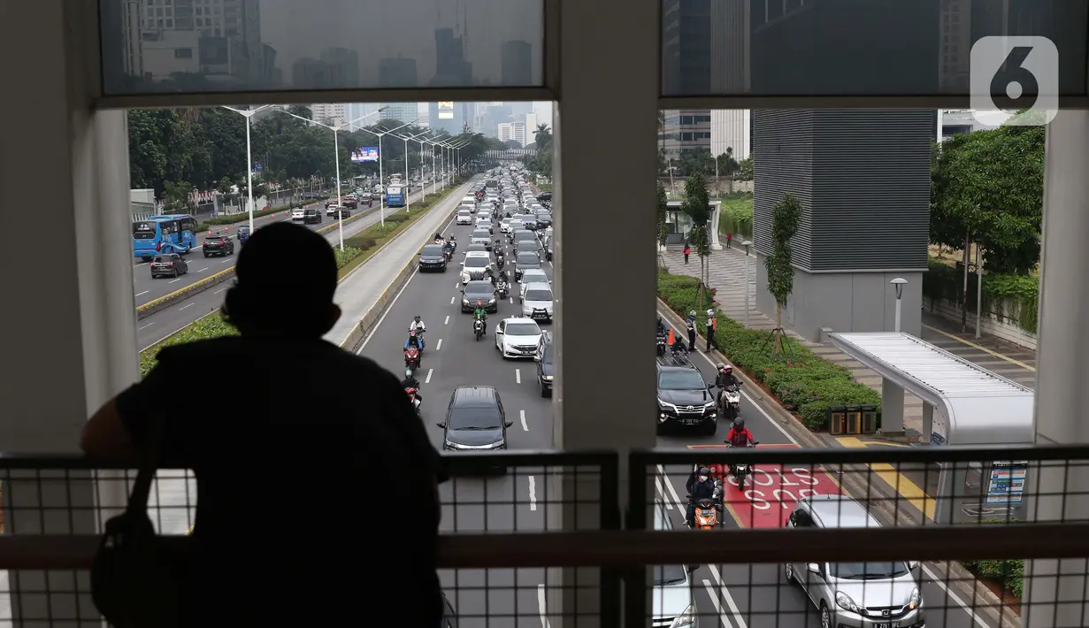 Warga melihat deretan kendaraan yang melintasi Jalan Jenderal Sudirman, Jakarta, Kamis (9/7/2020). Badan Pusat Statistik (BPS), mencatat masyarakat berpendapatan rendah paling terdampak pandemi Covid-19, akibatnya, secara ekonomi kelompok tersebut paling tertekan. (Liputan6.com/Helmi Fithriansyah)