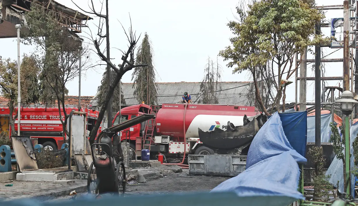 Petugas Pertamina menyedot sisa isi bahan bakar pada truk tangki yang terbakar di SPBU Jalan Kahfi 2, Jagakarsa, Sabtu (30/12). Penyedotan guna mengantisipasi hal tak diinginkan sebelum proses evakusi bangkai truk tangki. (Liputan6.com/Herman Zakharia)