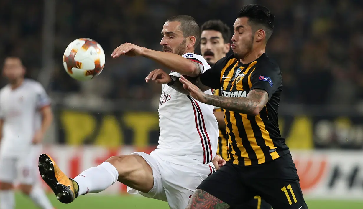 Pemain AC Milan, Leonardo Bonucci berebut bola dengan pemain AEK Athens, Sergio Araujo dalam laga lanjutan Grup D Liga Europa di Stadion Athens Olympic, Jumat (3/11). Tandang ke markas AEK, Milan hanya meraih hasil imbang 0-0. (AP/Petros Giannakouris)