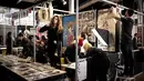 Peserta pameran mempersiapkan stan mereka selama Paris Tattoo Convention di Grand Halle de la Villette, Paris, Prancis, Jumat (9/3). Paris Tattoo Convention berlangsung dari tanggal 9 sampai 11 Maret. (Philippe LOPEZ/AFP)